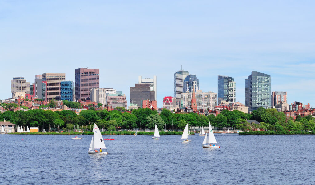 Boston Charles River panorama with urban skyline skyscrapers and sailing boat.